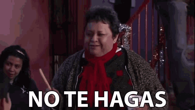 a woman in a red scarf is holding a stick in front of the words no te hagas