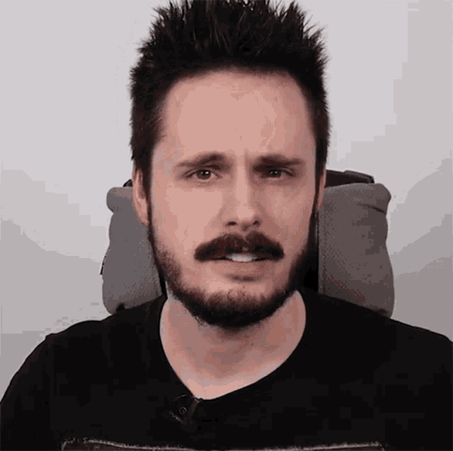 a man with a beard and mustache is wearing a black shirt that says ' nintendo ' on it