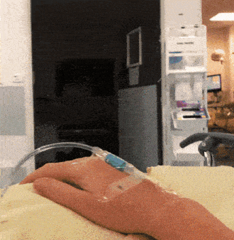 a person is laying in a hospital bed with an iv in their arm