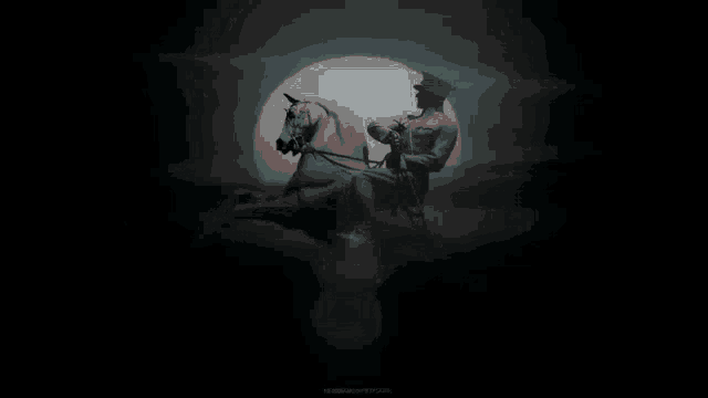 a statue of a man riding a horse in a dark room