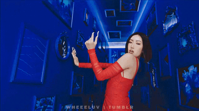 a woman is looking through a hole in a blue wall with tumblr written on the bottom right