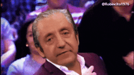 a man in a purple suit is sitting in a crowd with a robincito 1976 watermark