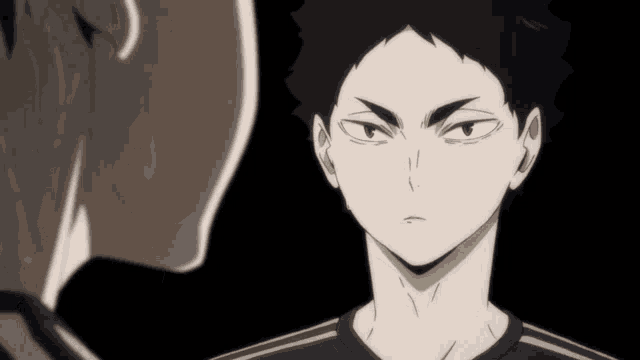 a man in a black shirt looks at another man in a black shirt