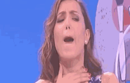 a woman is making a funny face while holding her chest .