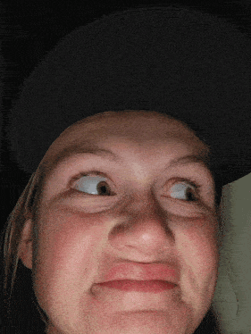 a girl wearing a hat makes a funny face