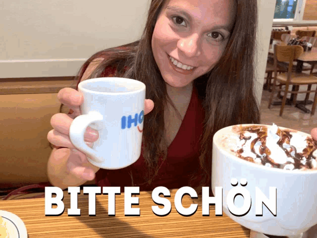 a woman is holding a mug that says bitte schon