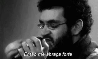 a man with a beard is singing into a microphone in a black and white photo .