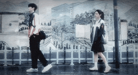 a boy and a girl are walking in the rain in front of a painting .