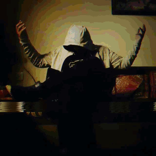 a blurry image of a person with their arms outstretched in the dark