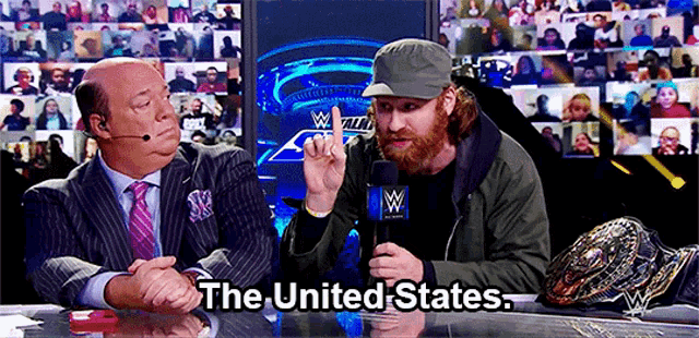 two men are sitting at a table with the words the united states on the bottom right