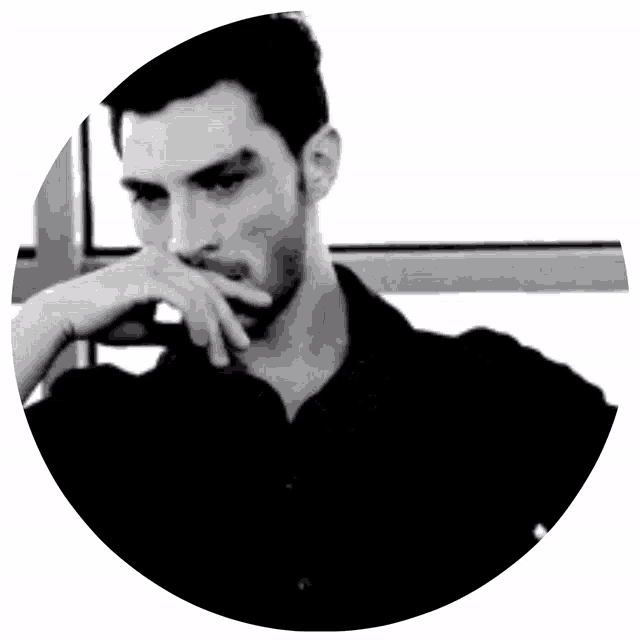 a black and white photo of a man with his hand on his mouth