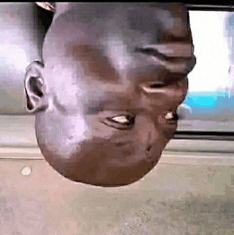 a man 's head is upside down in front of a screen .