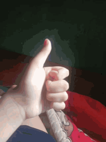 a close up of a person 's hand holding another person 's thumb
