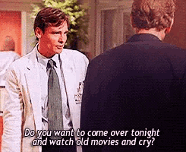 a man in a suit and tie is talking to another man in a lab coat .