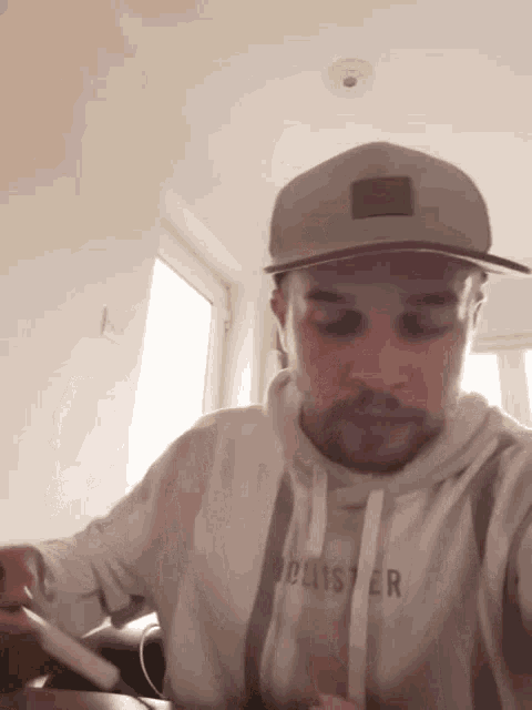 a man wearing a hat and a hollister sweatshirt