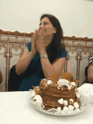 a woman sitting at a table with a cake on it