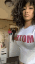 a woman with curly hair is wearing a white shirt that says bottom .