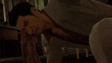 a man in a suit holds another man 's arm in a video game