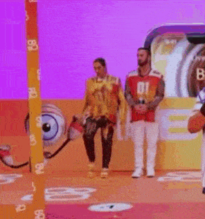 a man wearing a number 01 jersey is standing next to another man on a stage .
