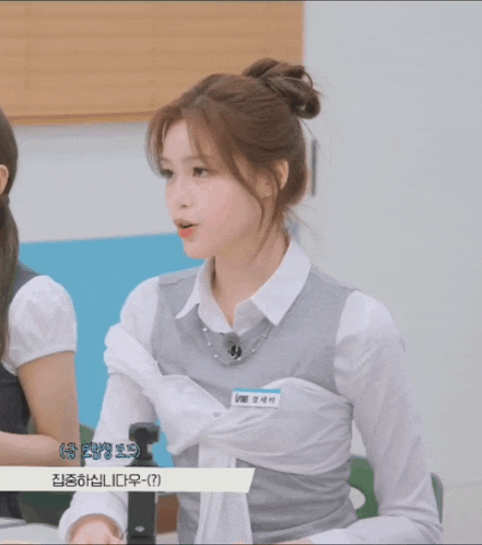 a girl in a white shirt and gray vest has a name tag that says ' a ' on it