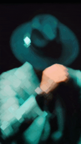 a blurry image of a man wearing a hat