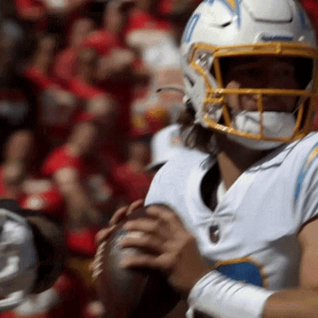 a football player wearing a helmet and holding a football