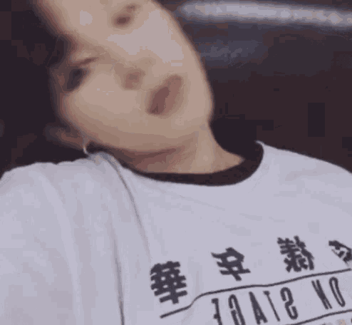a woman is wearing a white shirt with chinese writing on it