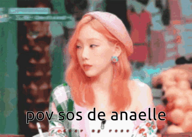 a woman with red hair is sitting at a table with the words pov sos de anaelle below her
