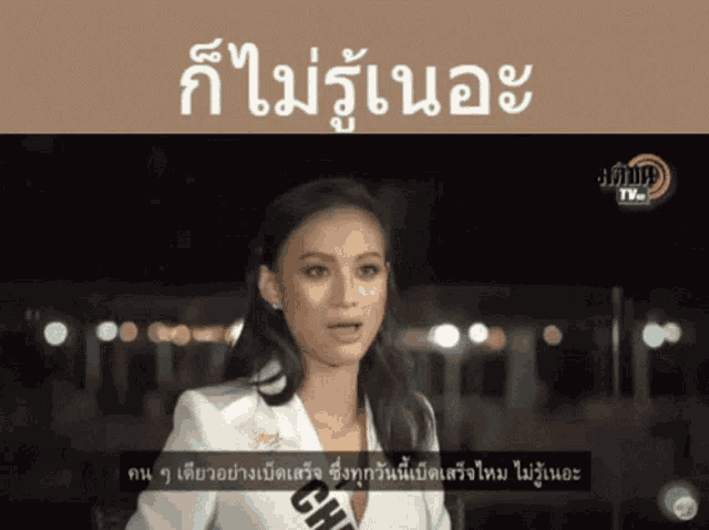 a woman in a white suit is talking on a tv screen with chinese writing
