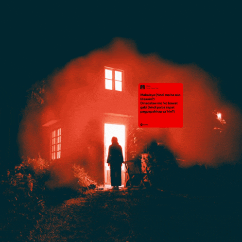 a person standing in front of a house with a red smoke coming out of the door