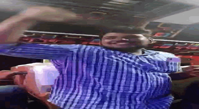 a man in a blue and white plaid shirt is standing upside down