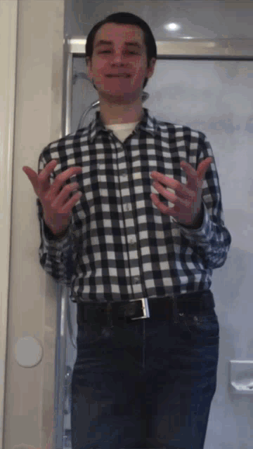 a man in a plaid shirt stands in front of a shower door