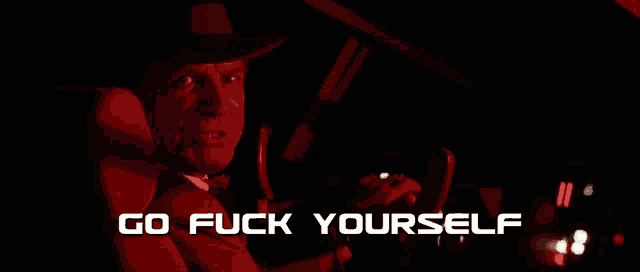 a man in a hat and bow tie is driving a car with the words go fuck yourself below him