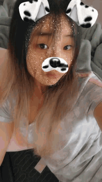 a girl with dalmatian ears on her head takes a selfie