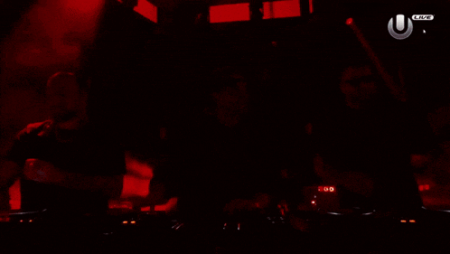 three men are playing music in a dark room with an u live logo