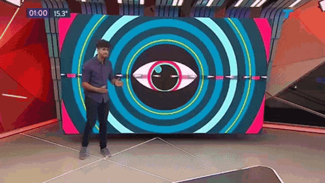 a man is standing in front of a large screen that says 00 15.3