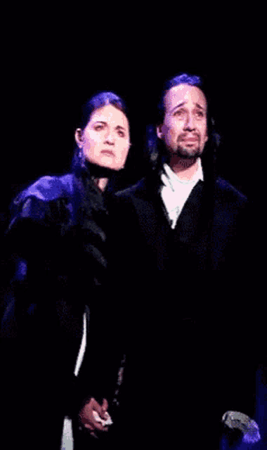 a man and a woman are standing next to each other on stage