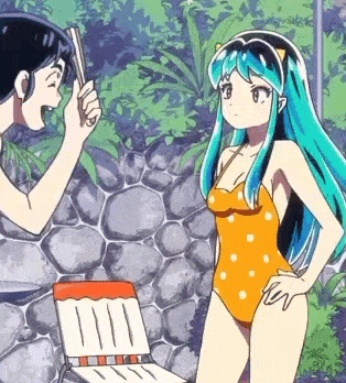 a man and a woman are standing next to each other in front of a rock wall
