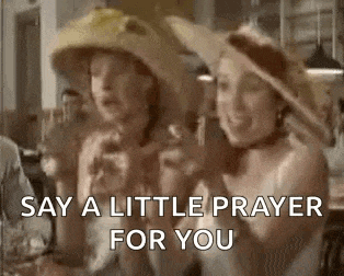 a couple of women wearing hats are sitting at a table and talking to each other .