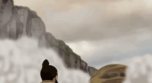a man in a ponytail is standing in front of a mountain
