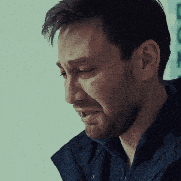 a close up of a man 's face with a tear running down his cheek