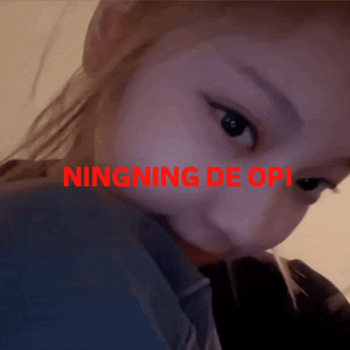 a close up of a woman 's face with the words ningning de opi written above her