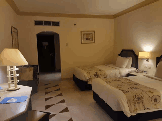 a hotel room with two beds and a table