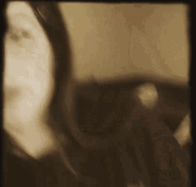 a blurred image of a person 's face with a reflection of a person in the mirror