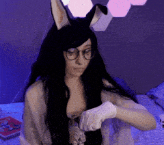 a woman wearing bunny ears and gloves is sitting on a bed