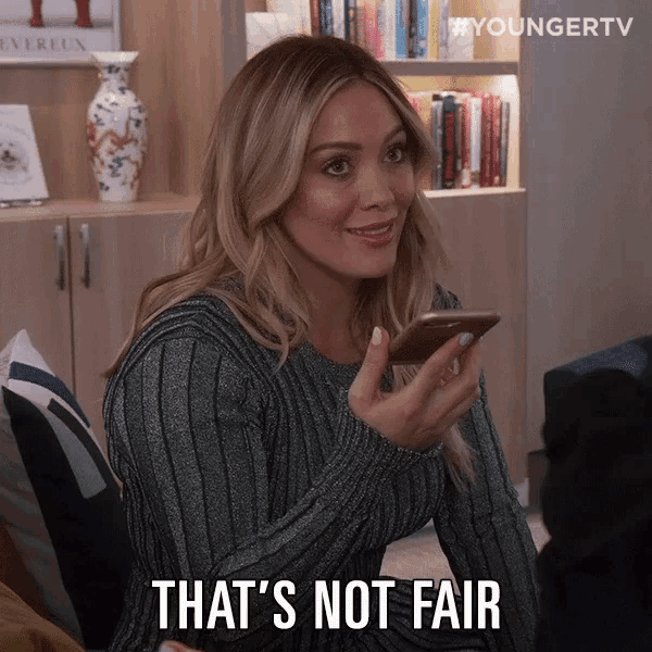 a woman holding a cell phone with the words that 's not fair on her face