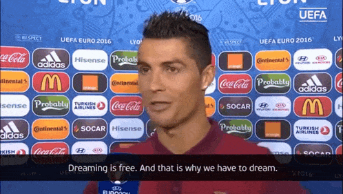 a man stands in front of a uefa euro 2016 advertisement wall