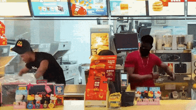 a man wearing a mcdonald 's hat is standing at a counter