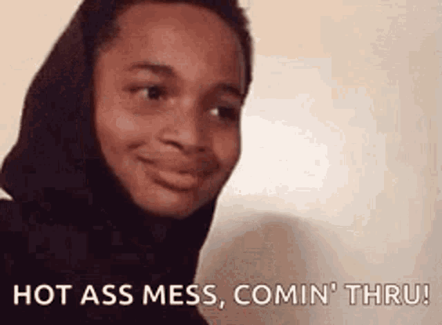 a young man wearing a hooded jacket is smiling and says hot ass mess comin thru .