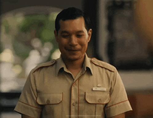 a man in a tan uniform has a name tag that says ' mr. wong ' on it